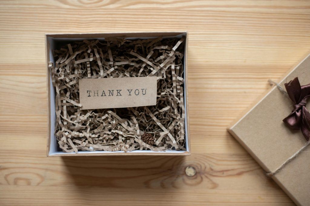 Photo by Monstera Production: cardboard-gift-box-with-postcard-on-table