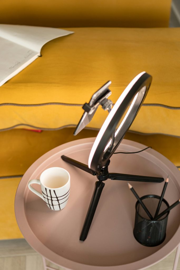 Ring light on a small table with a cup and pencils.